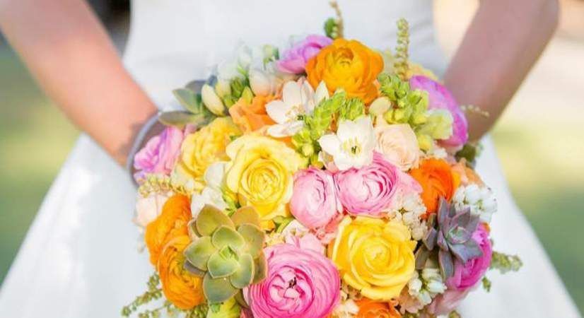 A Bride in a White Dress is Holding a Bouquet of Colorful Flowers — Suncoast Flowers in Birtinya, QLD