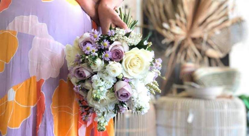 A Woman in a Purple Dress is Holding a Bouquet of Flowers — Suncoast Flowers in Birtinya, QLD
