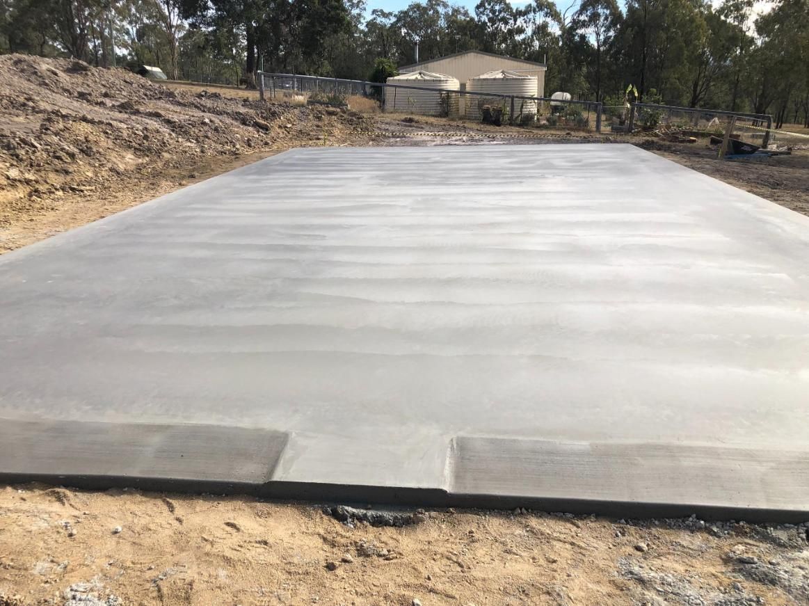 A Construction Site With a Yellow Excavator in the Background — Burgess Concreting In Kingaroy, QLD