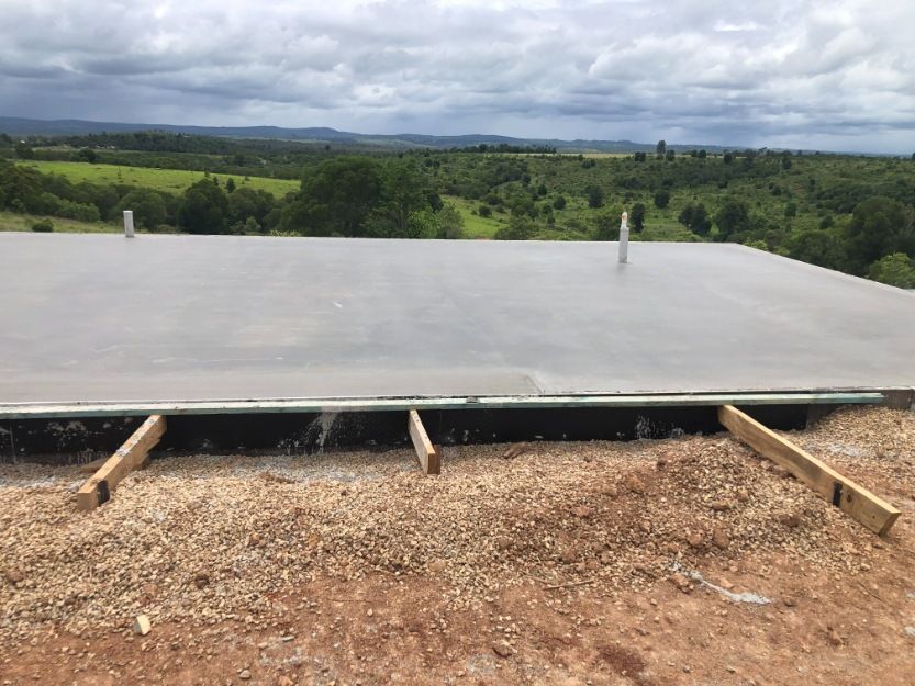 A Large Concrete Slab is Sitting on Top of a Dirt Field — Burgess Concreting In Kingaroy, QLD