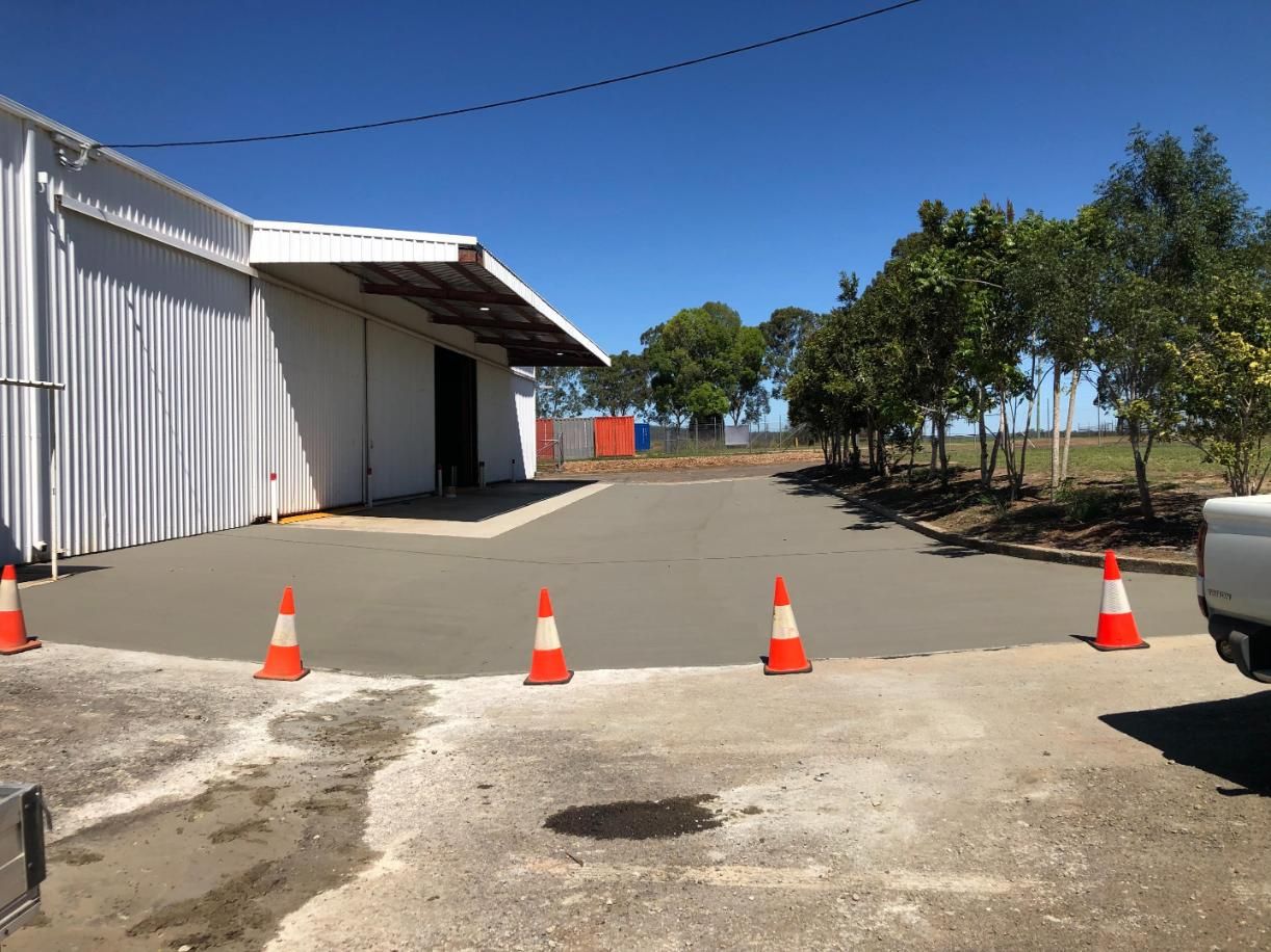 A White Truck Is Parked In Front Of A Building With Orange And White Traffic Cones — Burgess Concreting In Kingaroy, QLD
