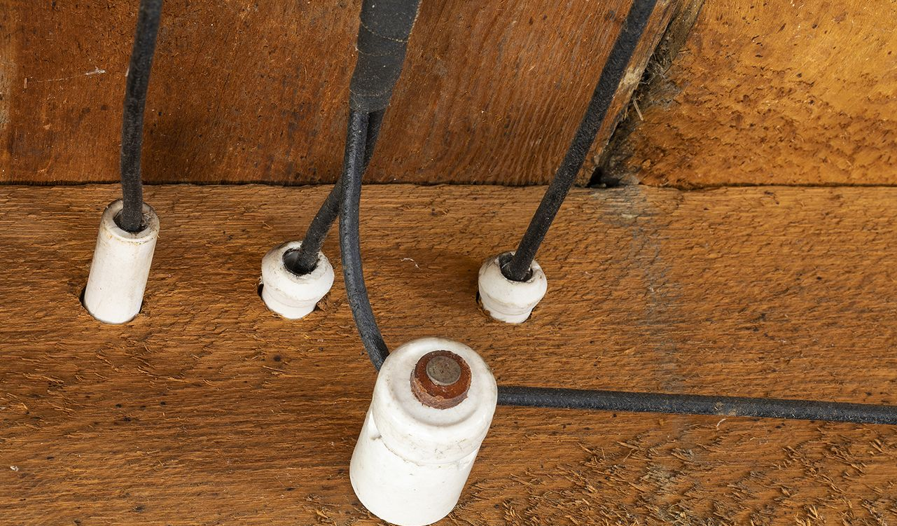 Metal pipes run vertically along a wall, held in place by clamps.