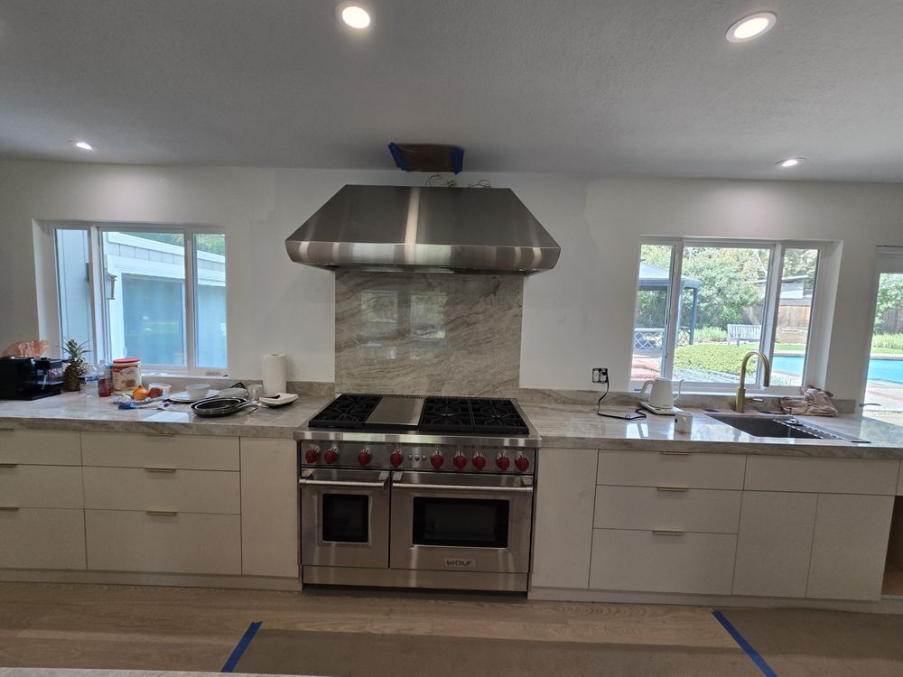 Exposed electrical wires protrude from ceiling holes above a concrete floor. A foot is in the lower part of the frame.