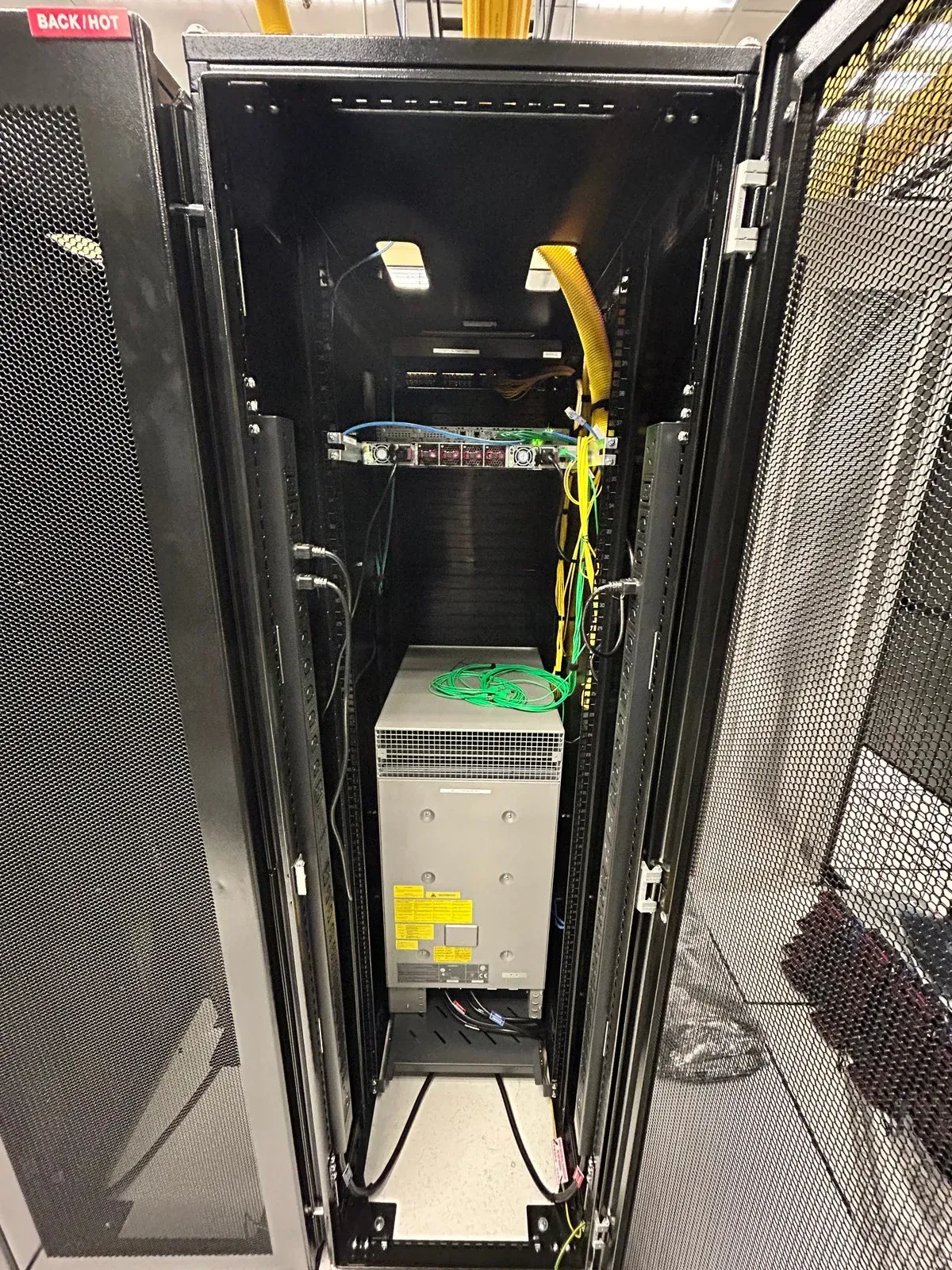 Two men are standing in an empty room with black walls