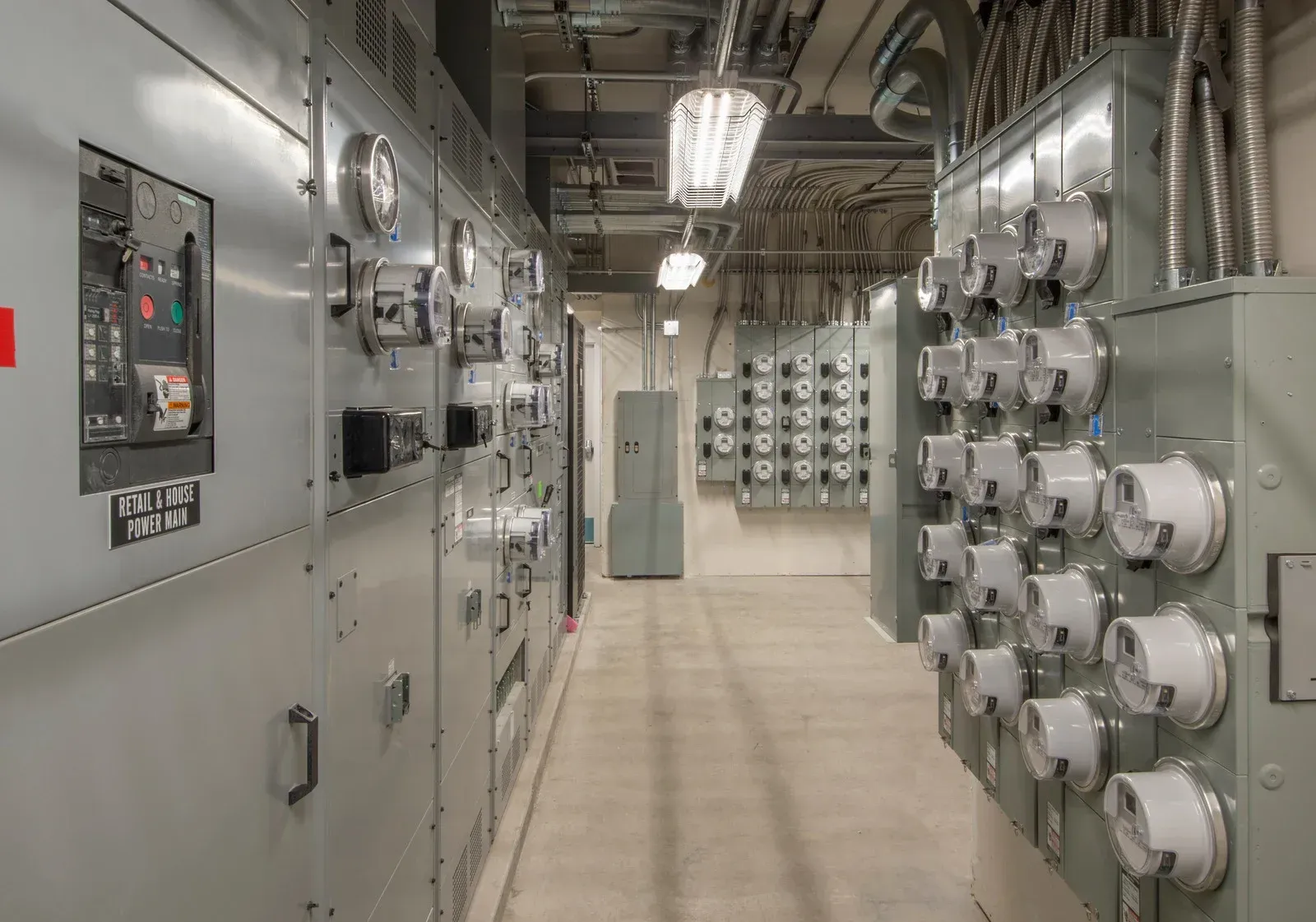 Electrical equipment room with gray panels, meters, and wiring.