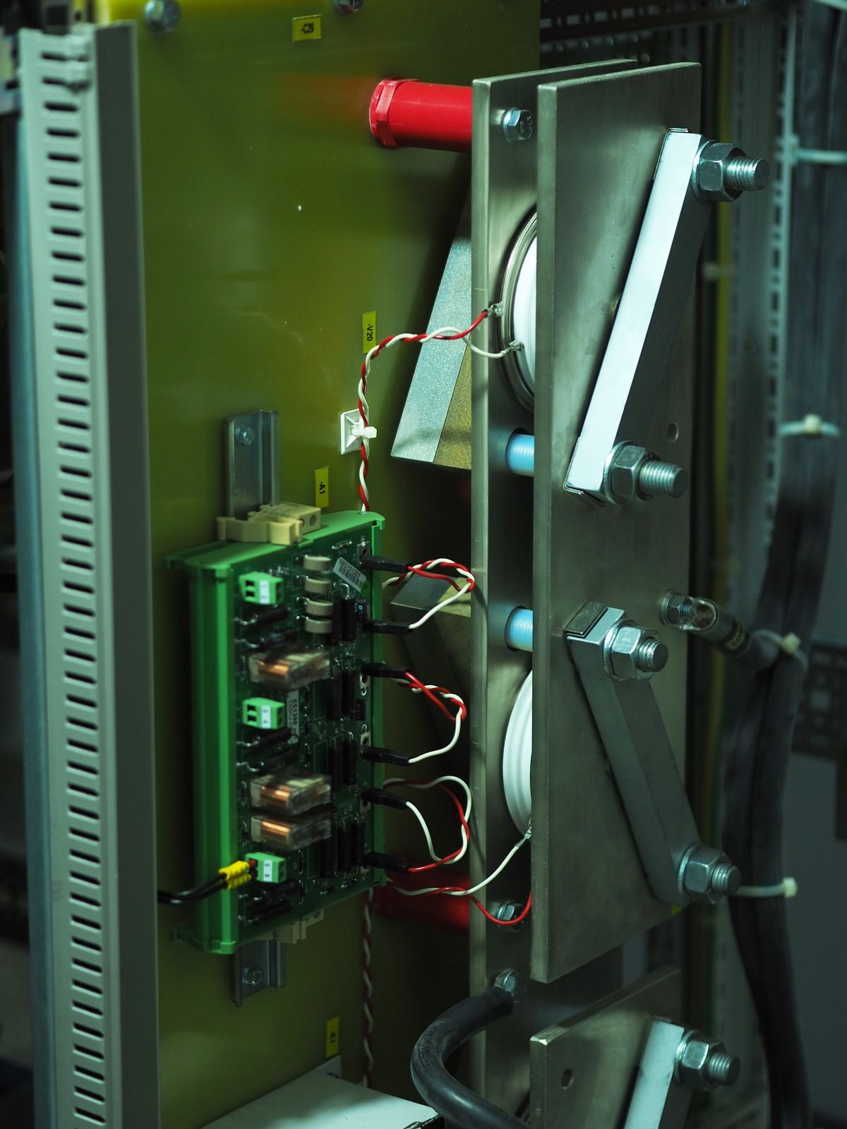 Electronic components mounted on a green circuit board, with wiring and metal supports.