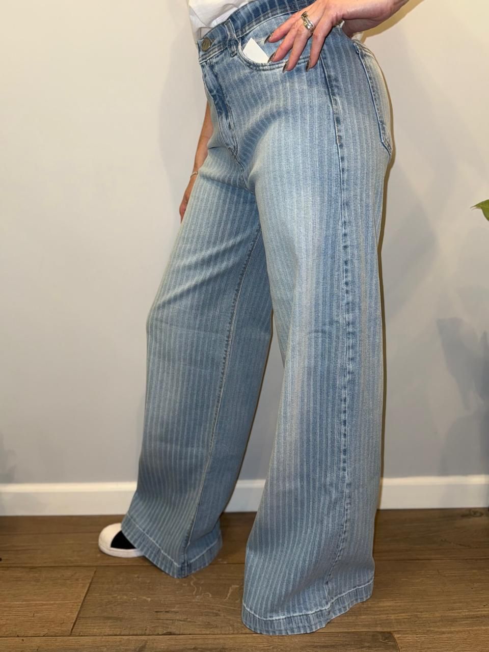 Mujer que viste pantalones vaqueros anchos de raya diplomática de color azul claro