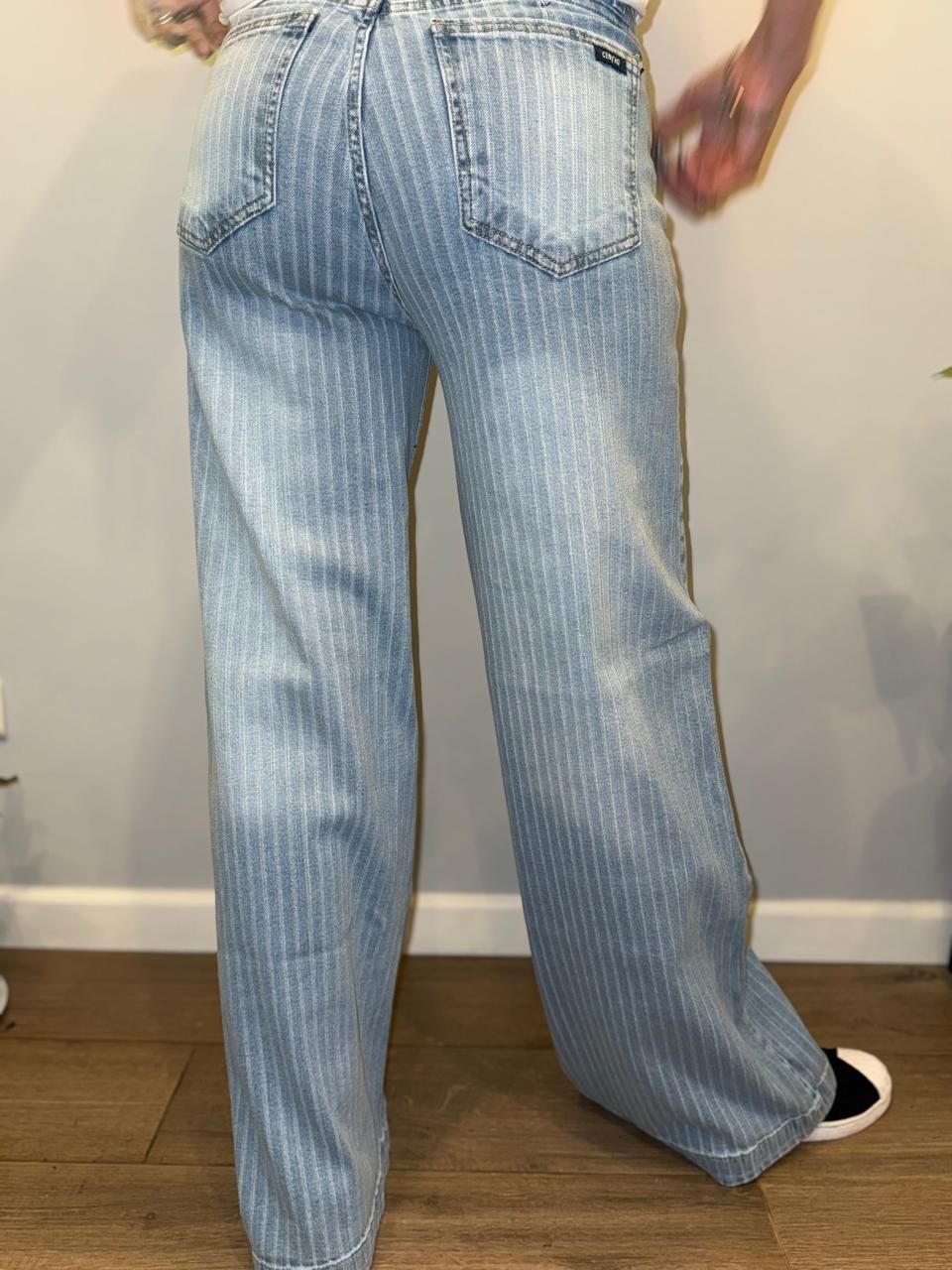 Mujer que viste pantalones vaqueros anchos de raya diplomática de color azul claro