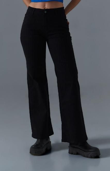 Pantalones negros acampanados combinados con botas negras gruesas.