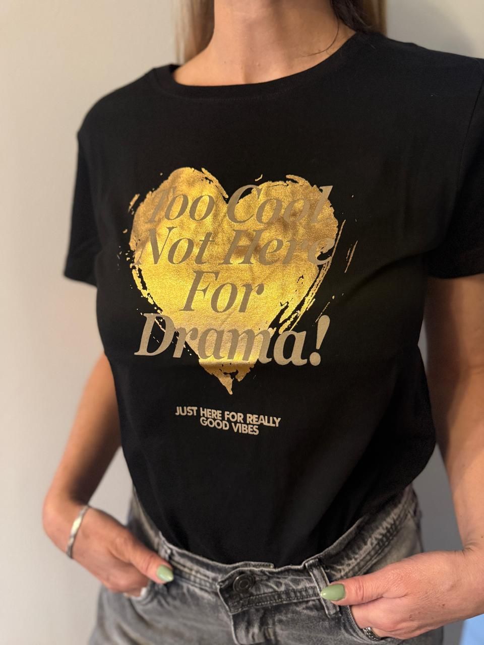Dos camisetas, negra y tostada, con gráfico de corazón dorado y el texto