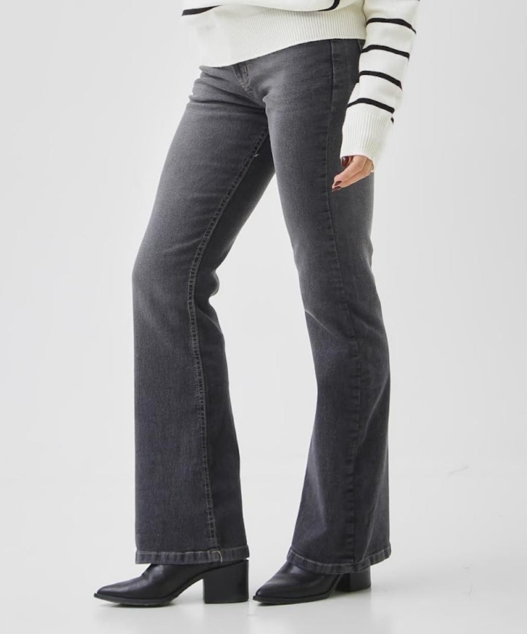 Mujer con vaqueros grises, vista trasera. Vaqueros de cintura alta con etiqueta de la marca.