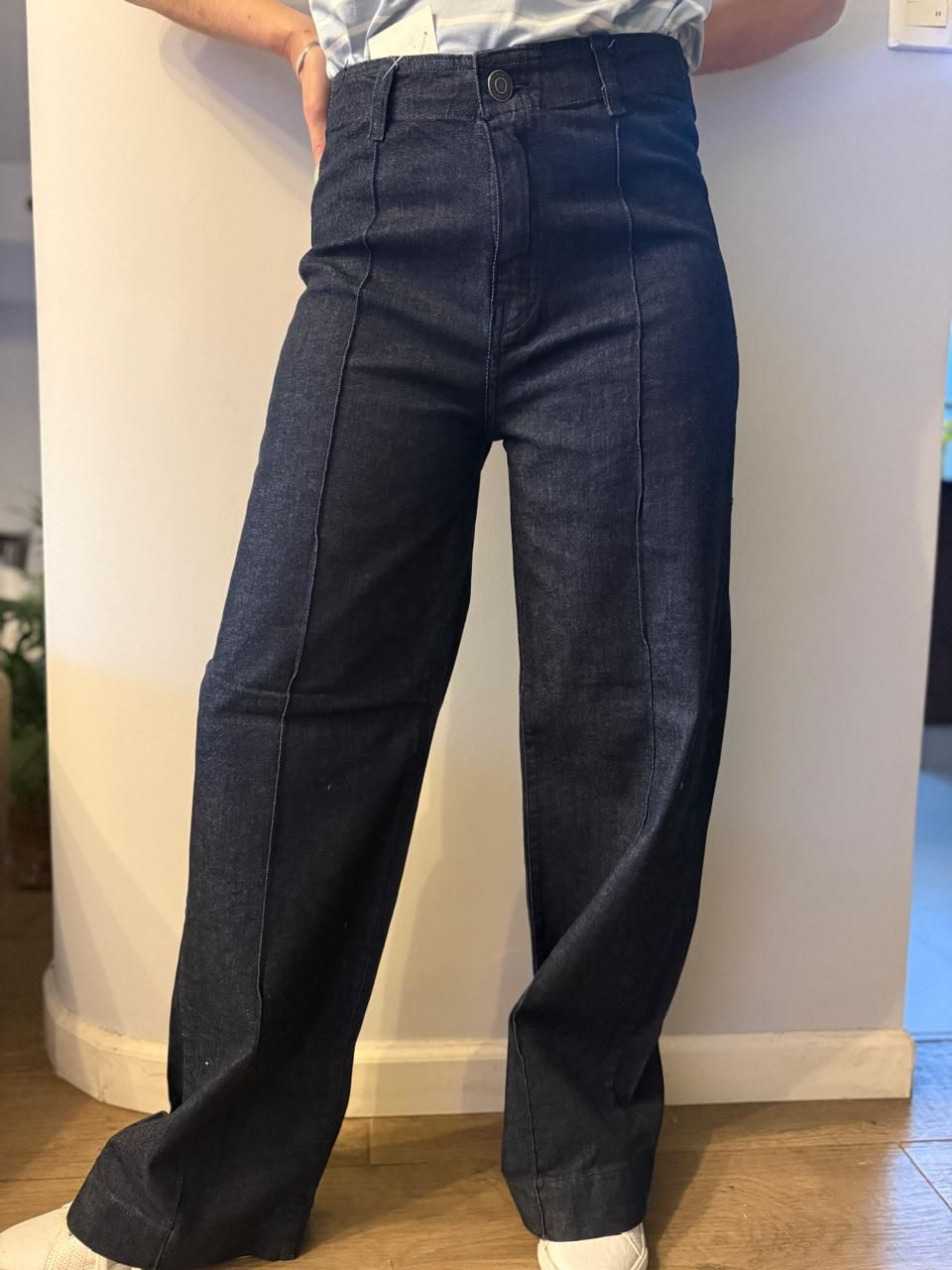 Persona que viste pantalones de mezclilla de color azul oscuro, de cintura alta y con costuras visibles.