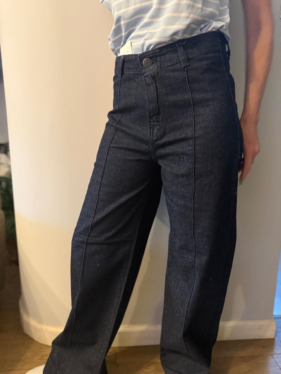 Persona que viste pantalones de mezclilla de color azul oscuro, de cintura alta y con costuras visibles.