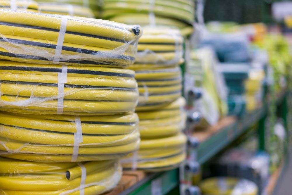 Bunch of Yellow hose Stacked on top of each Other on a Shelf in a Store — Hardware Supplies in Dayboro, QLD
