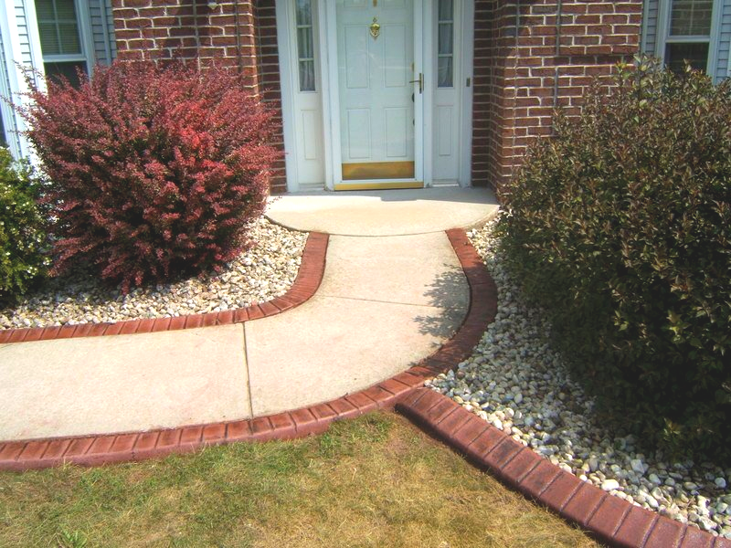 A brick house with a walkway leading to the front door
