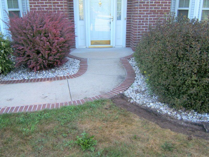 A brick house with a walkway leading to the front door