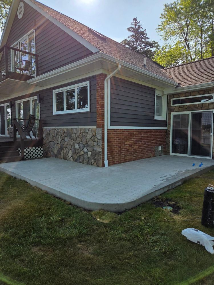 A large house with a concrete patio in front of it.