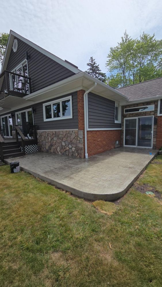 A large house with a concrete patio in front of it.