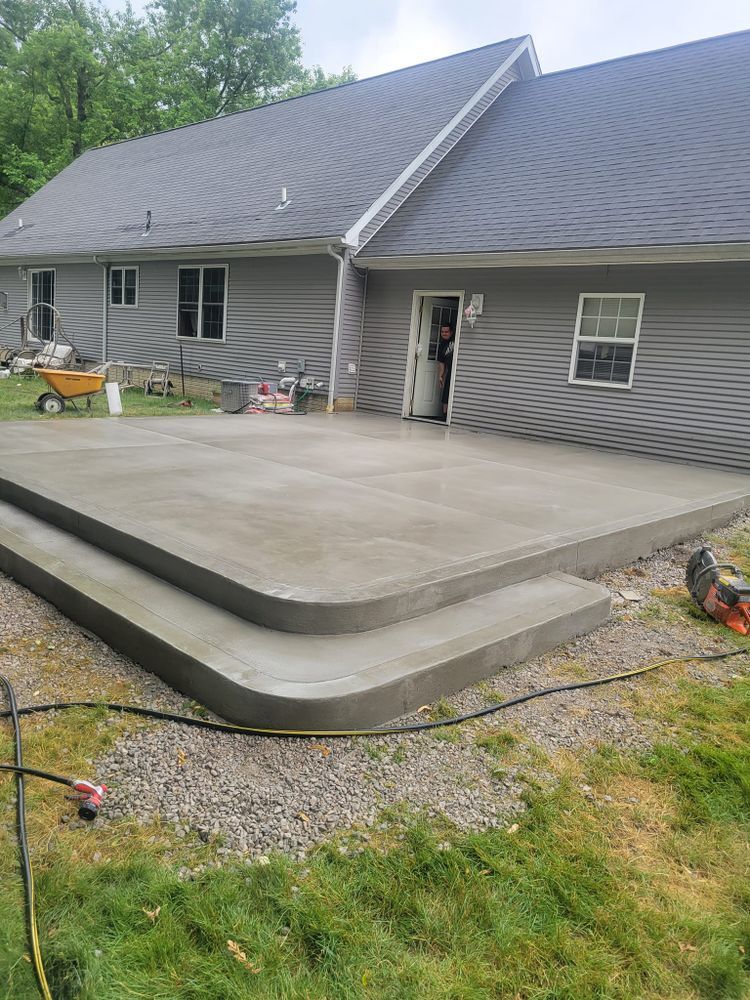A concrete deck is being built in front of a house.