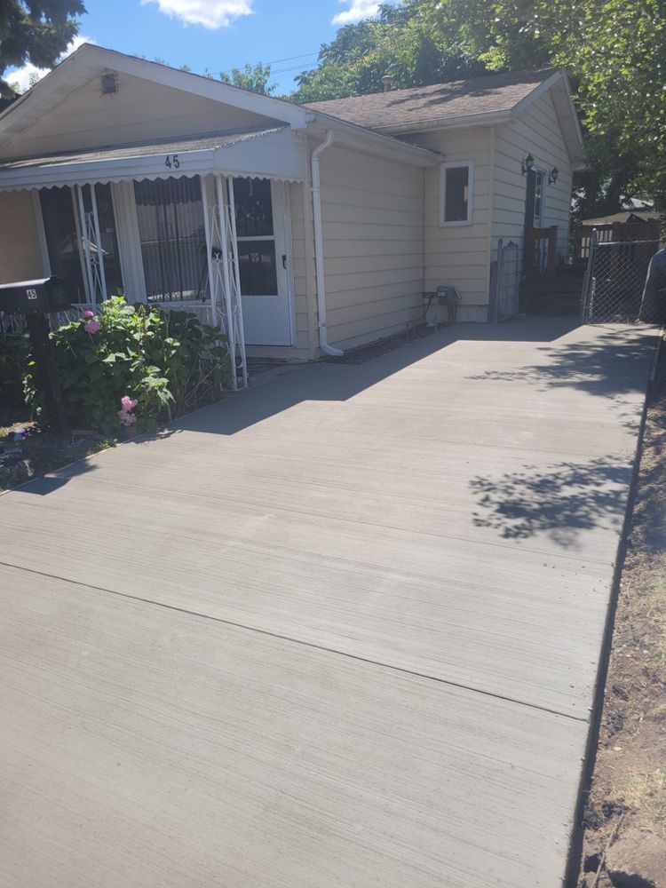 A house with a concrete driveway in front of it