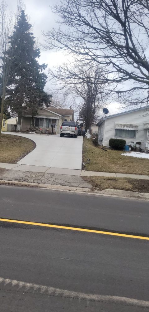 A car is parked in a driveway next to a house.