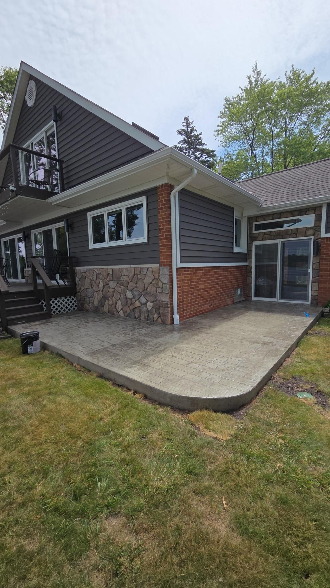 A large house with a concrete patio in front of it.