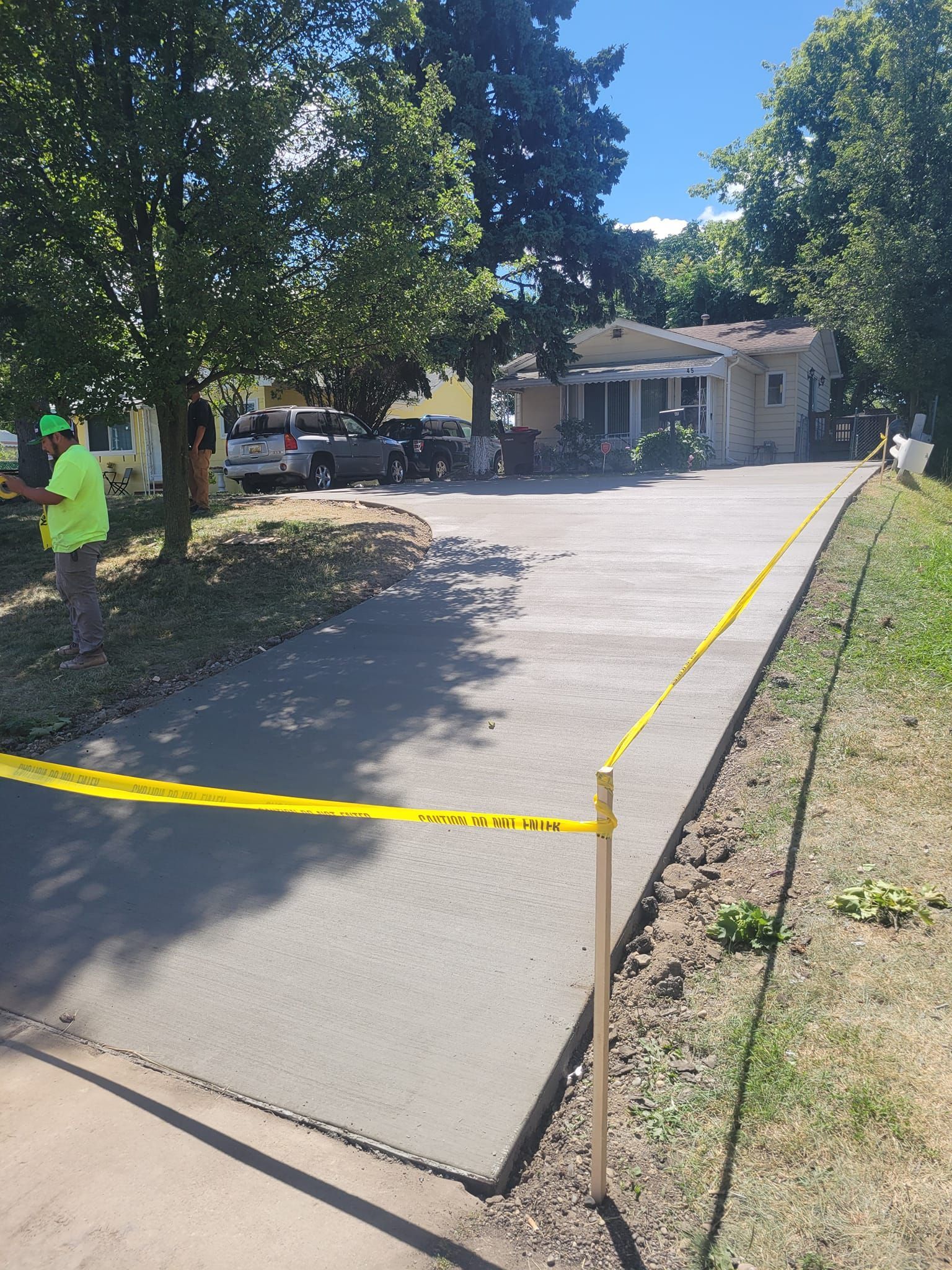 A concrete driveway is being built in front of a house.