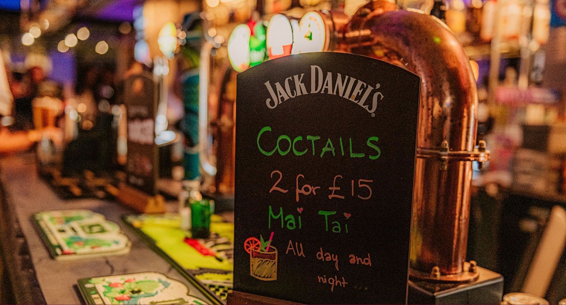 A blackboard in a bar advertising jack daniel 's cocktails.