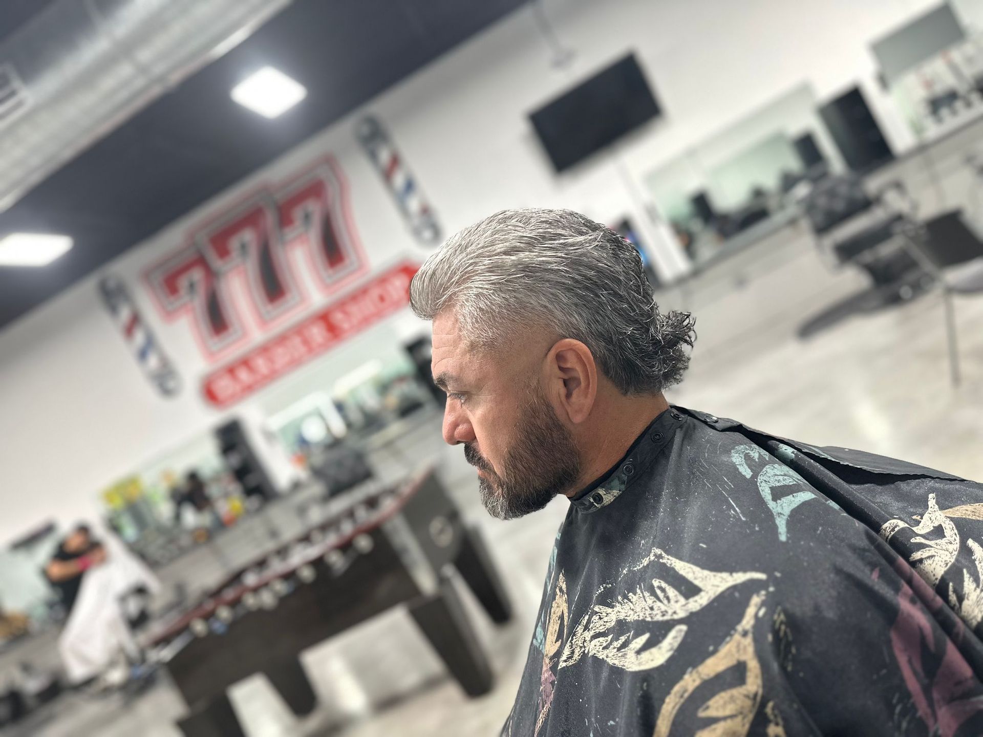 Man with mullet haircut in a barber shop. The barber shop has a