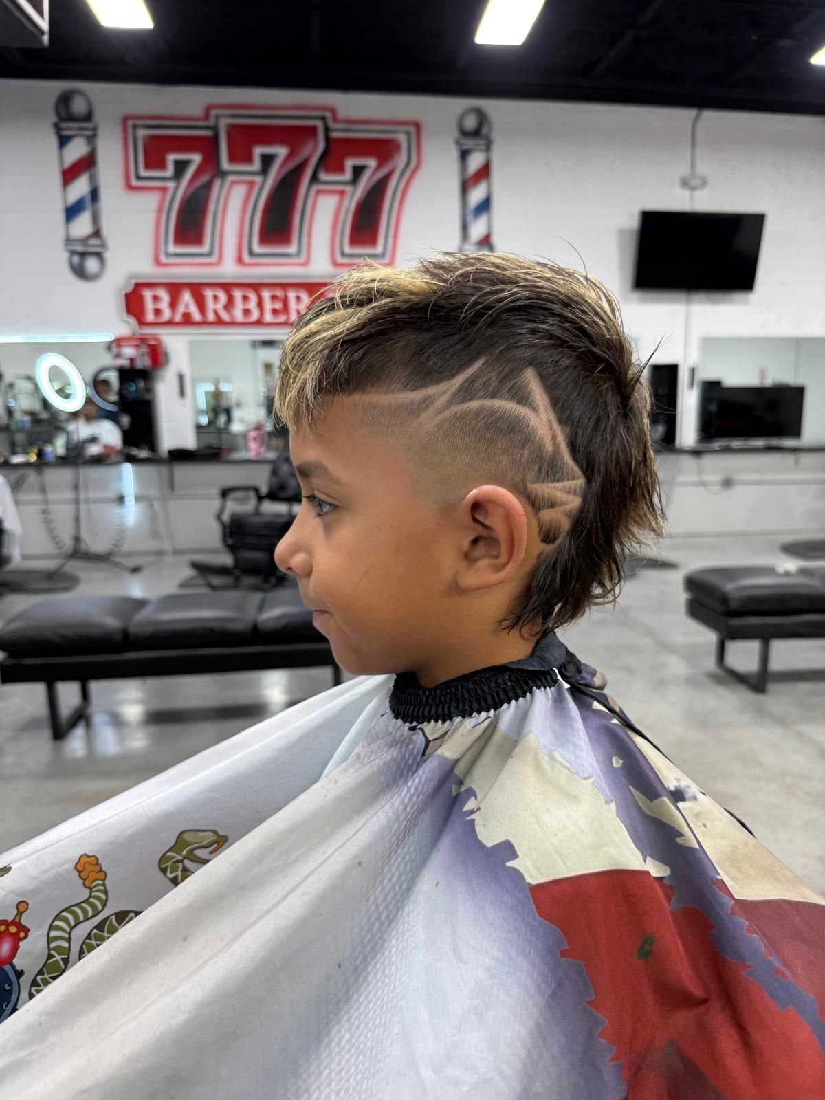 Boy with a mullet haircut and shaved side design in a barbershop.