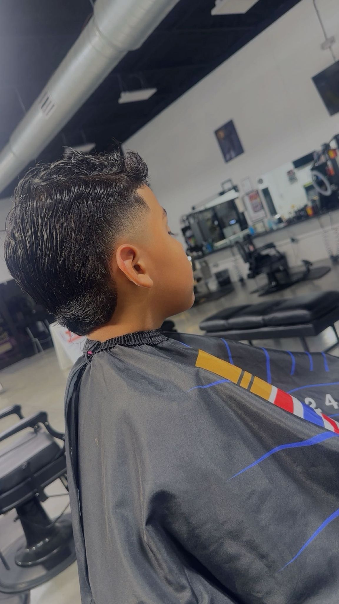 Person with textured hair, fresh haircut, in a barber shop setting.