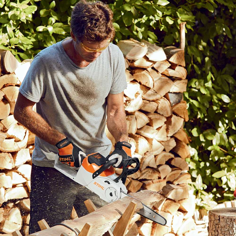 Man Cutting the Wood in to Small — Stihl Shop Atherton & Atherton Motorcycles in Atherton, QLD
