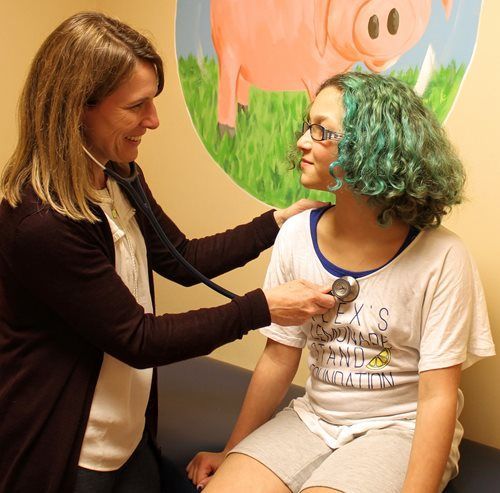 Pediatrician listening to the heart beat of a girl