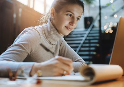 Woman reading good news from business partners on lap