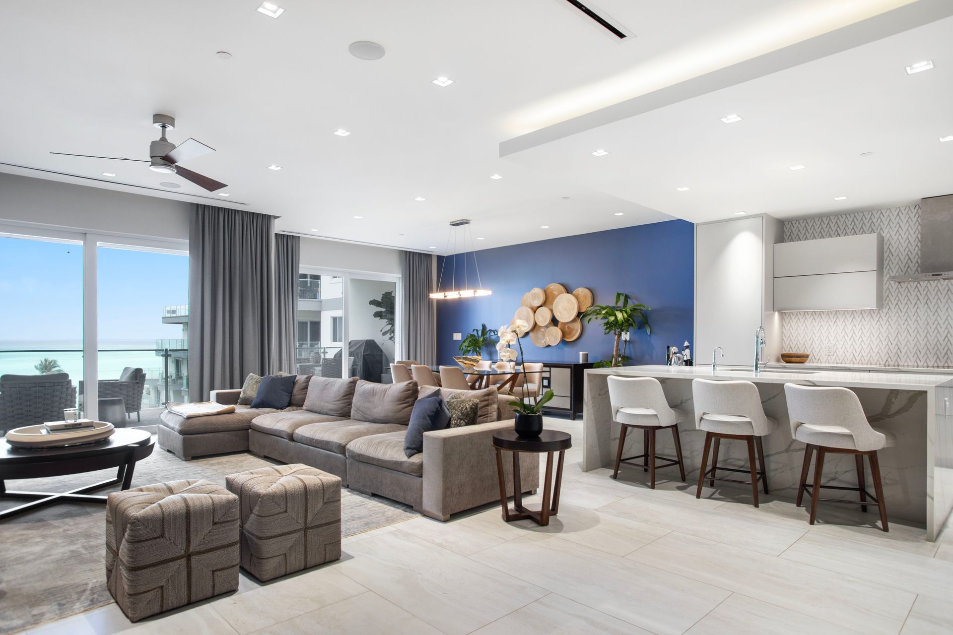 A living room with a large sectional couch and a ceiling fan in one cable beach Nassau Bahamas
