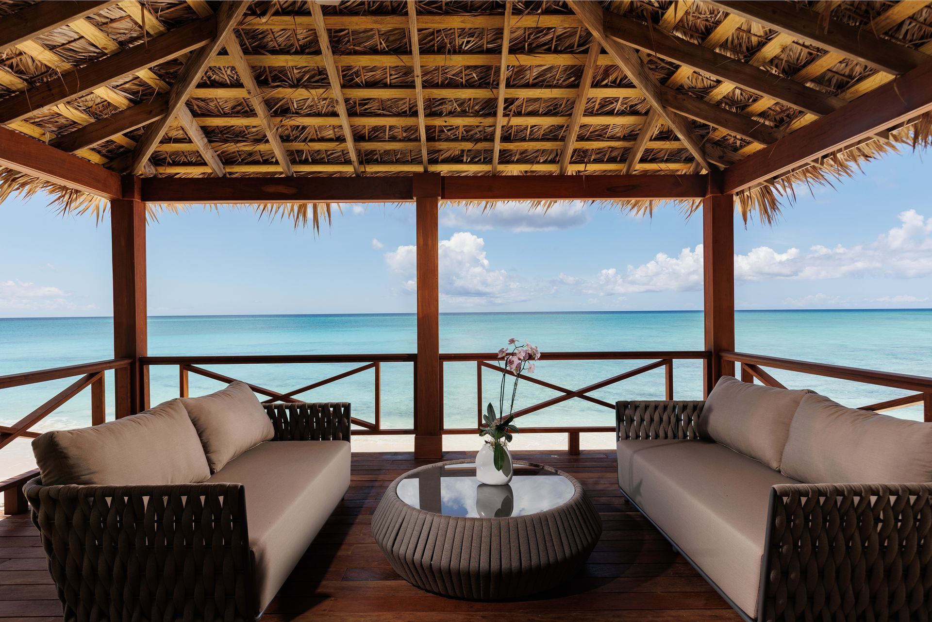 A living room with a large sectional couch and a ceiling fan in one cable beach Nassau Bahamas