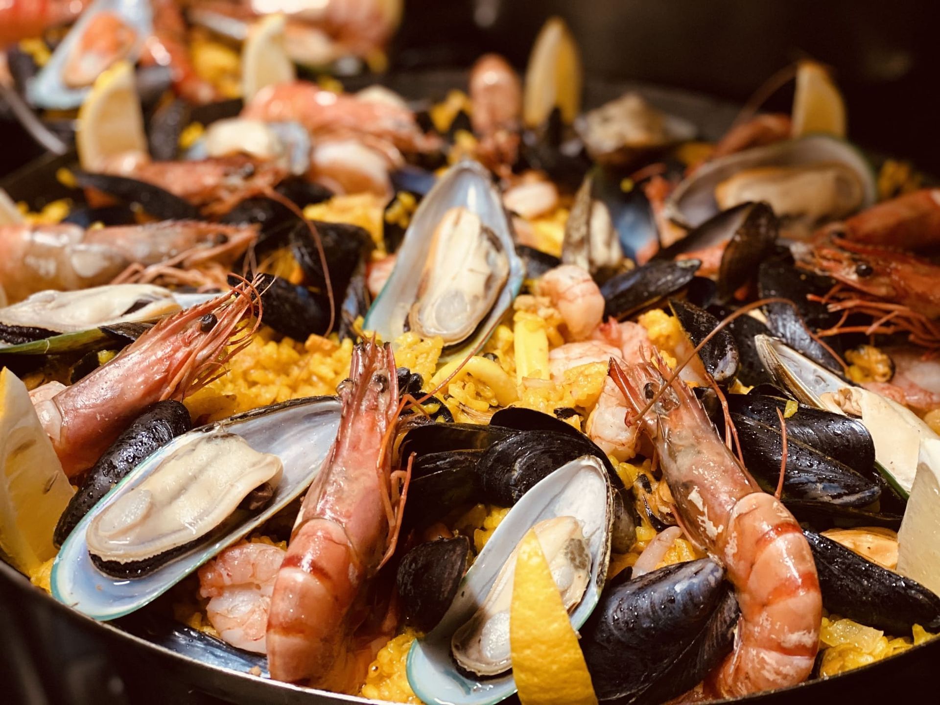 a pan filled with shrimp , mussels , and rice .