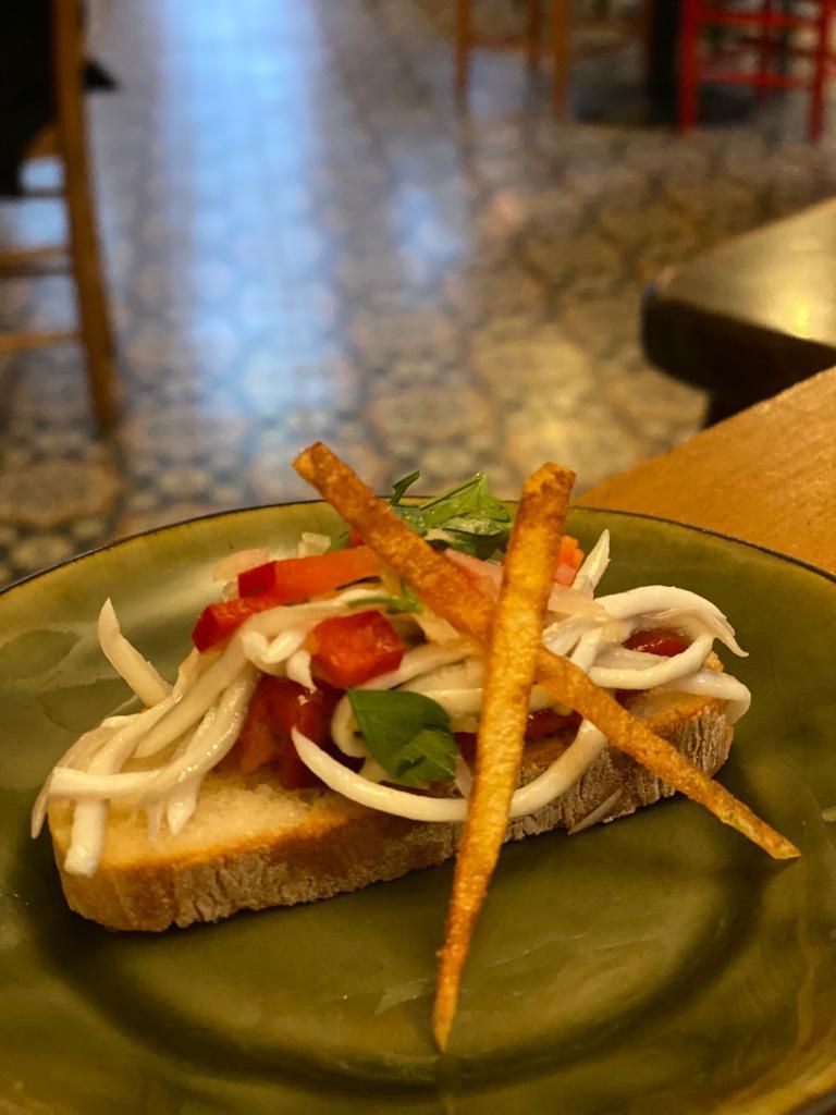 a green plate topped with a sandwich and vegetables on a table .