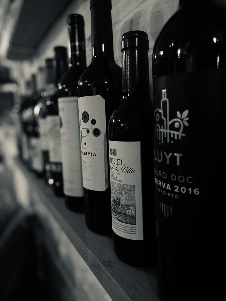 several bottles of wine are lined up on a shelf including luyt