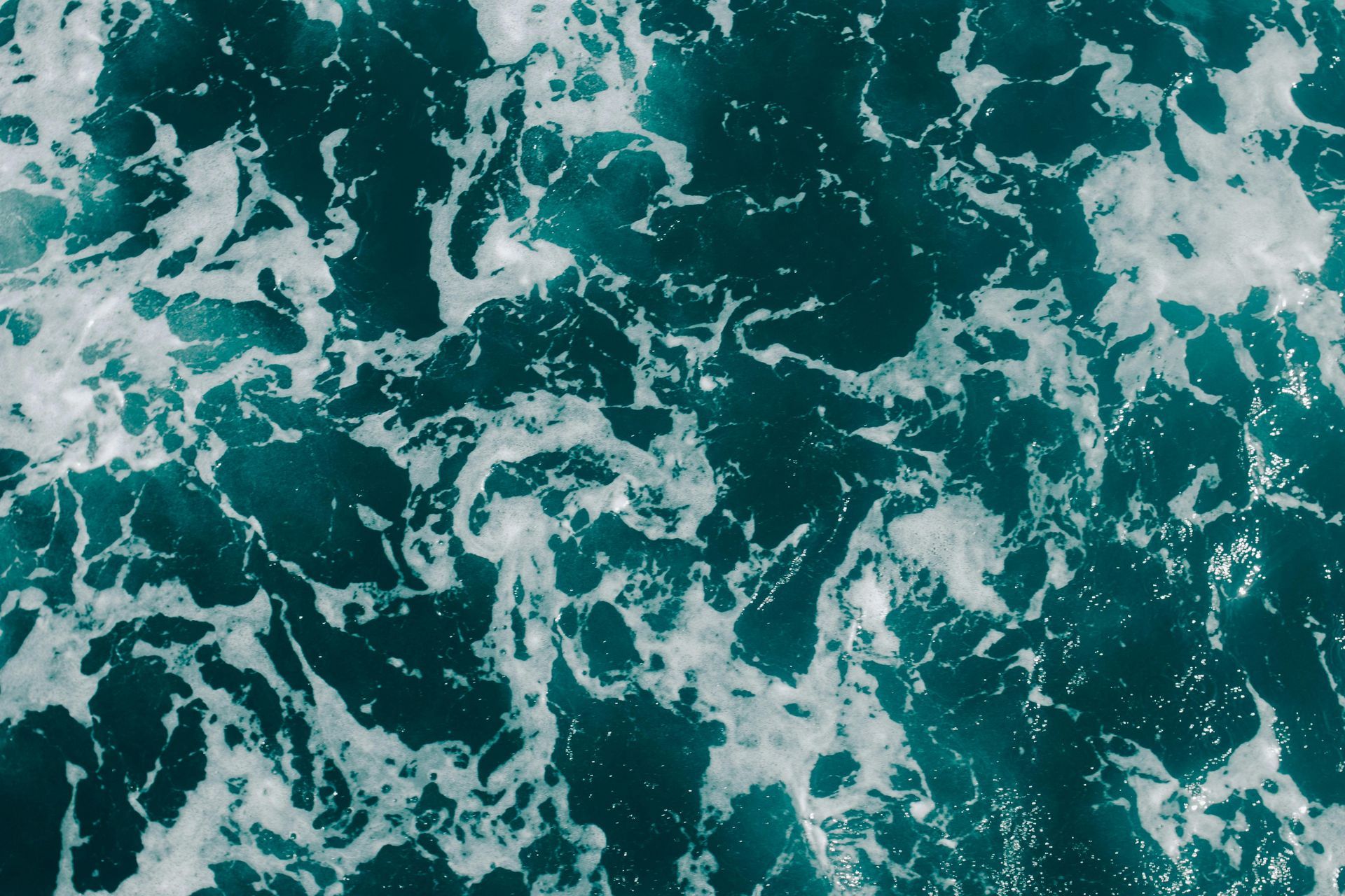 Turquoise ocean water with white foam swirls.