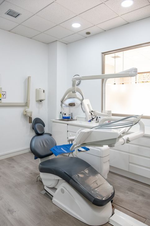 Dentist's office: dental chair, overhead light, cabinets, window, and various tools.