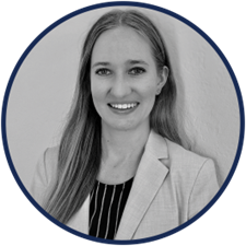 A woman in a suit is smiling in a black and white photo