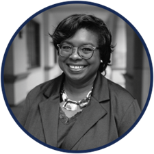 A black and white photo of a woman wearing glasses and a necklace