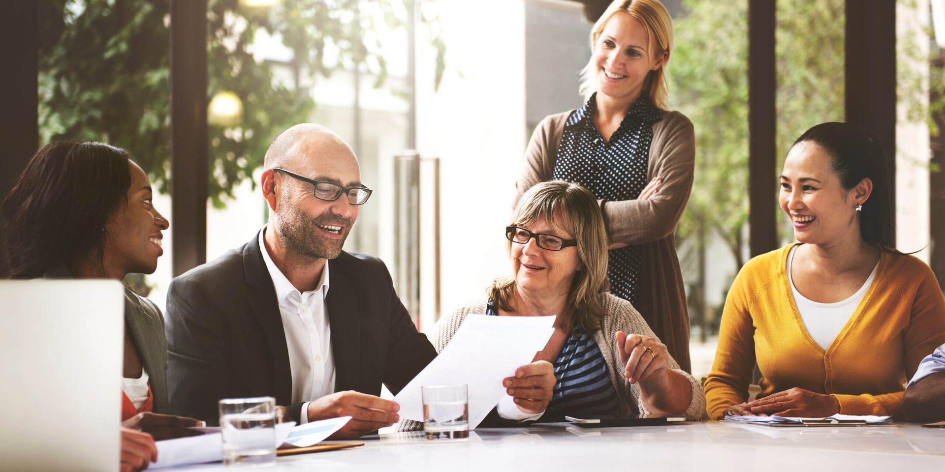 A group of people are sitting around a table having a meeting.