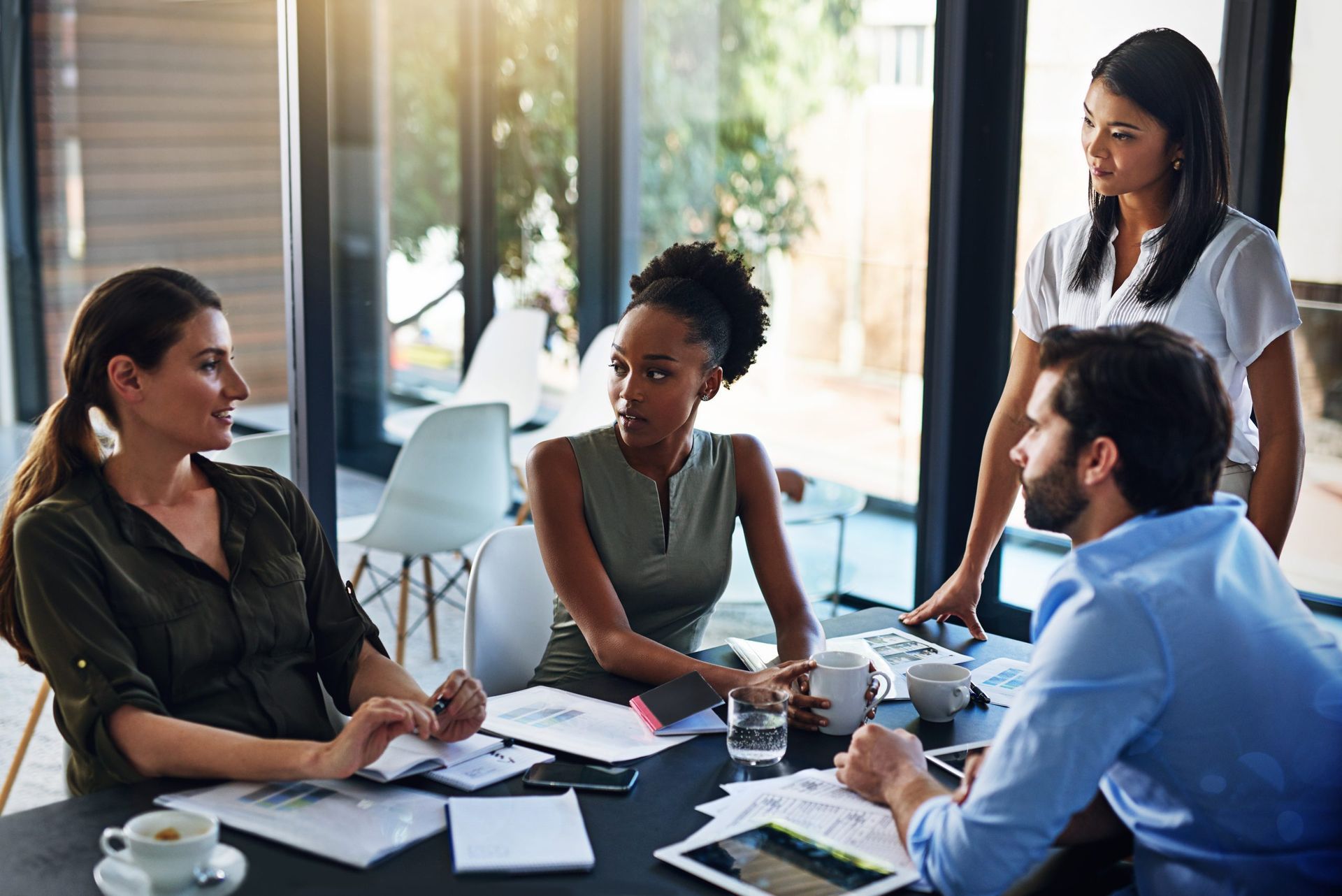 A group of people are sitting around a table having a meeting.