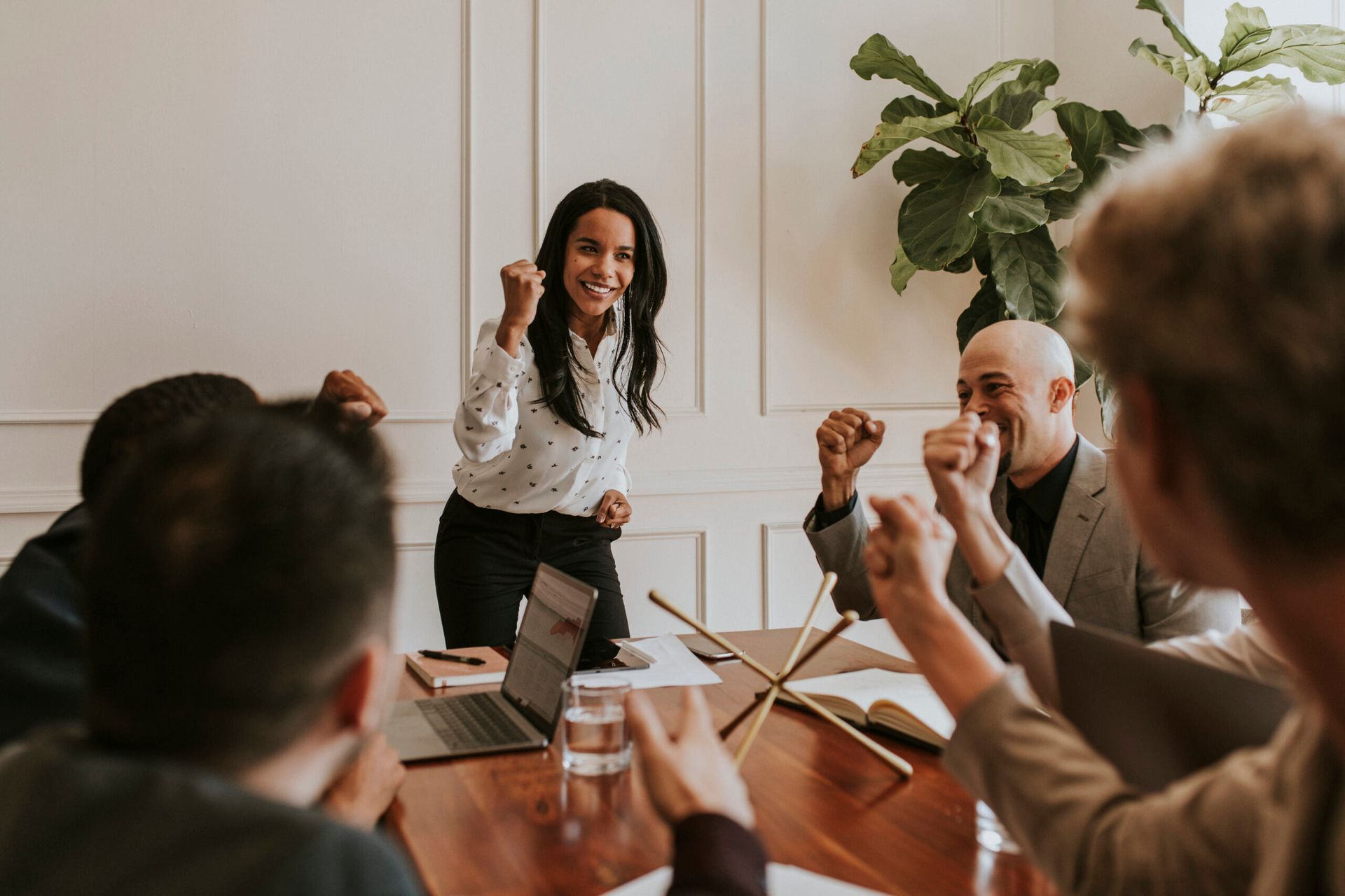 A woman is giving a presentation to a group of people at a conference table.