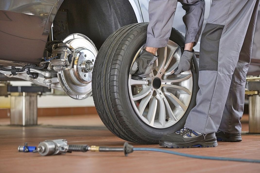 gommista in officina mentre effettua il montaggio di un pneumatico