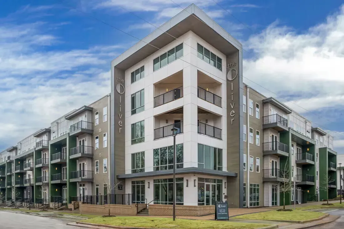 Exterior view of The Oliver apartment building with balconies and a main entrance