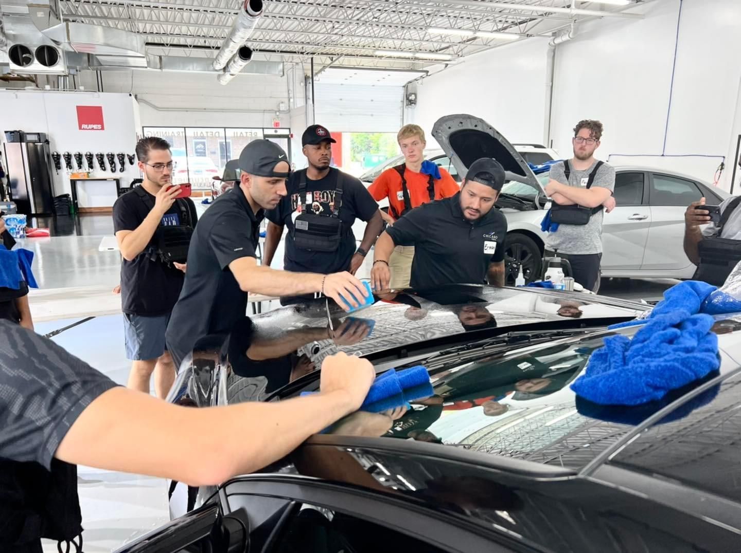 A group of men are working on a car in a garage.