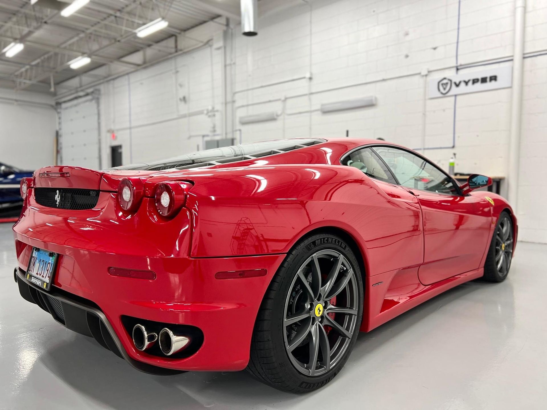 A red ferrari sports car is parked in a garage.